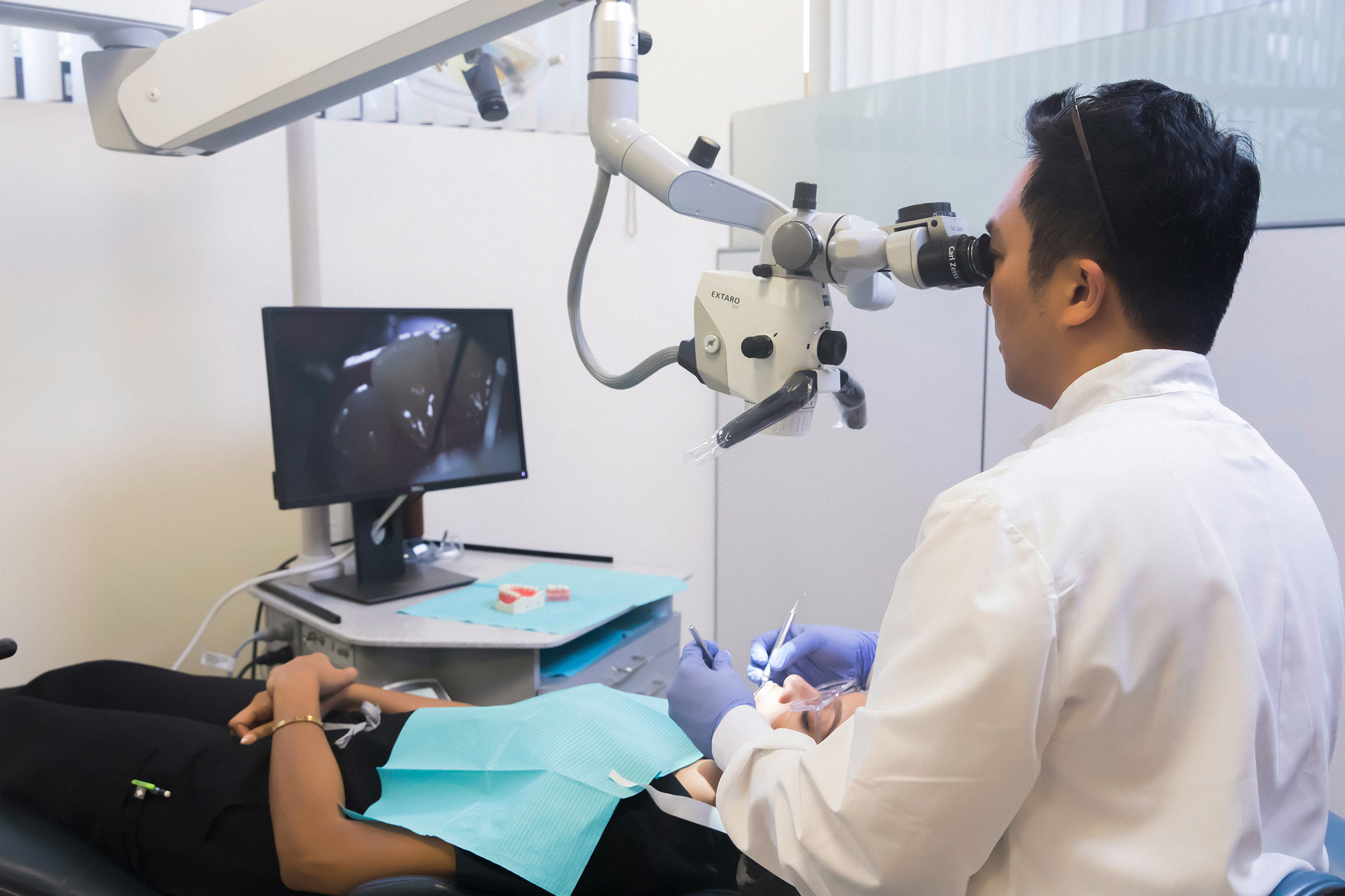 Assistant Professor of Clinical Dentistry Jin-Ho Phark uses a high-powered microscope to examine a patient's teeth and gums. | HANNAH BENET