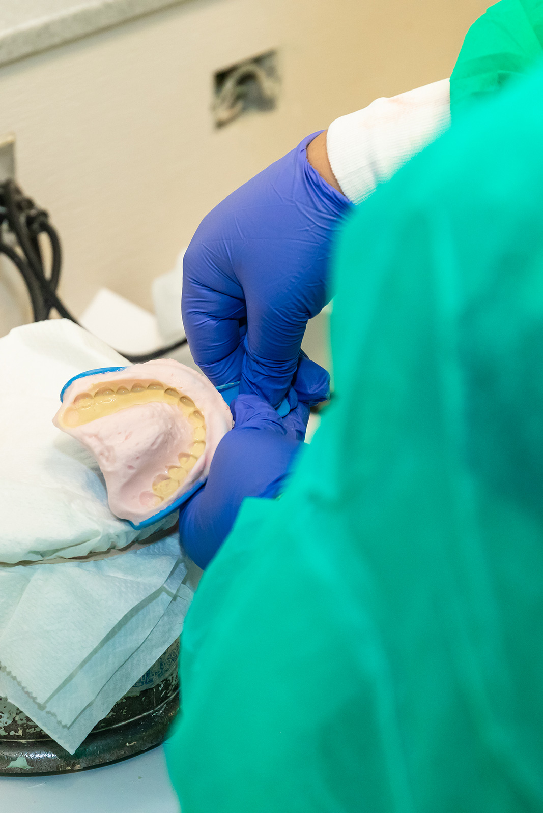 <em>Left:</em> Dental Explorers use oranges to practice administering anesthetic shots. <em>Right:</em> Dental Explorers learn to make impressions. | DEREK TAM