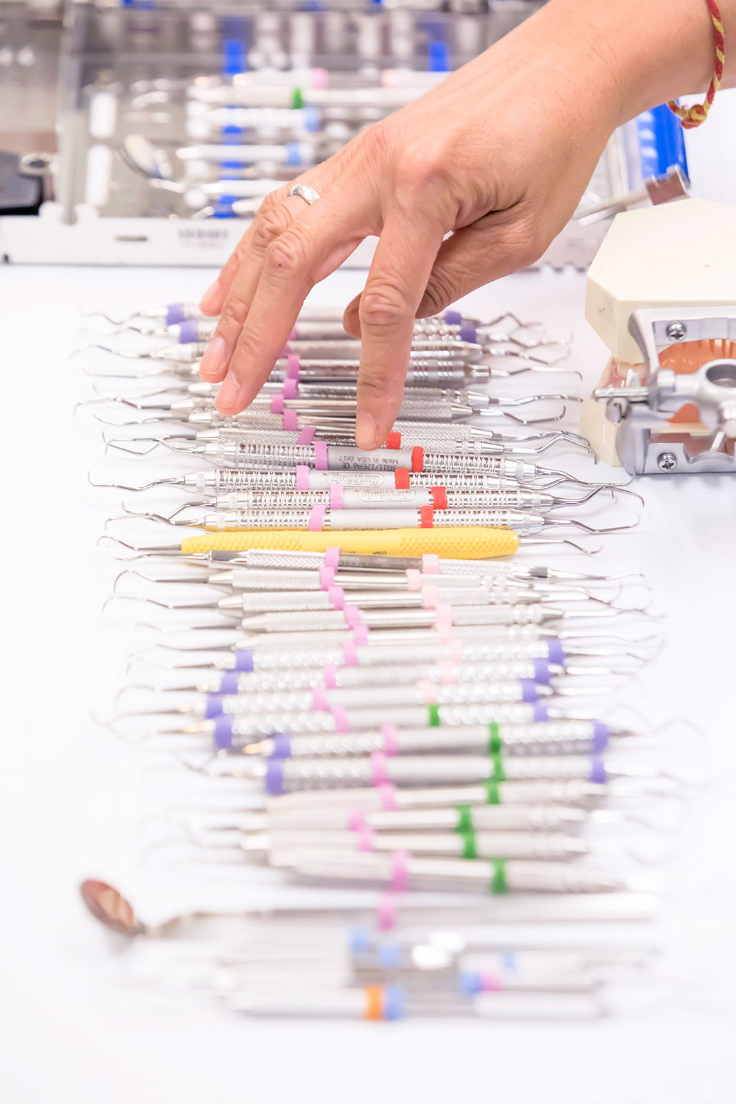 <em>Left:</em> Dental hygiene students craft bleaching trays use vacuum forming machine. <em>Right:</em> Dental hygiene students learn to use a number of scaling instruments for different oral health conditions. | NATE JENSEN
