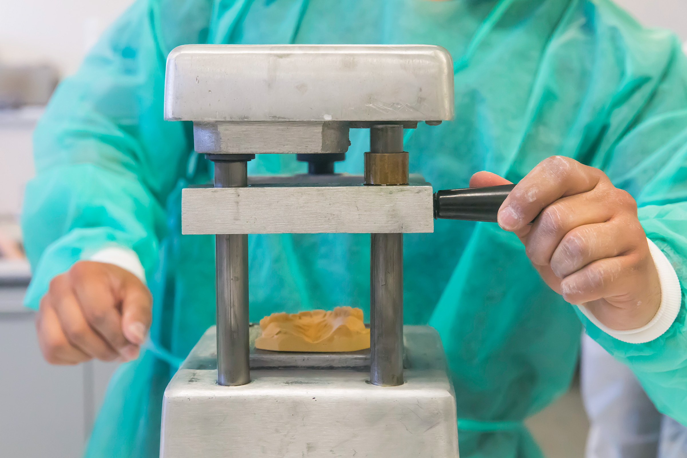 A dental hygiene student places mold in vacuum-form machine to craft a bleaching tray. | NATE JENSEN