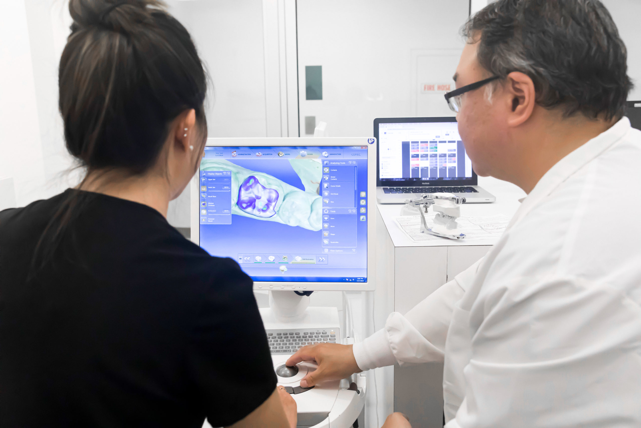 <em>Left:</em> Digital printer used to make try-ons for denture patients. <em>Right:</em> Reviewing high-fidelity intraoral scans.  | NATE JENSEN